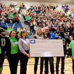 Washington State Dairy Ambassador Anna Teachman (in crown) (from left), Monroe dairy farmers Jim and Dolores Werkhoven, and Seattle Seahawk Marcus Trufant present a $30,000 check to Gateway Middle School at a Nov. 28 assembly. (Contributed photo)