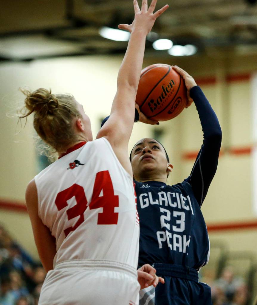 Glacier Peaks Alexyss Newman (23) takes a shot as Snohomishs Kyra Beckman (34) defends during a game on Dec. 19, 2017, at Snohomish High School. (Ian Terry / The Herald)