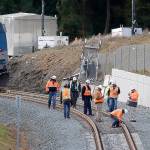 Workers look over tracks near the rear engine of a crashed Amtrak train on Tuesday in DuPont. The train that careened off an I-5 overpass on Monday. (AP Photo/Elaine Thompson)