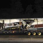 A damaged Amtrak passenger train car sits on a flatbed truck after being lifted from the tracks at the site of the derailment of an Amtrak train in Dupont on Tuesday. (Thomas James/Pool via AP)