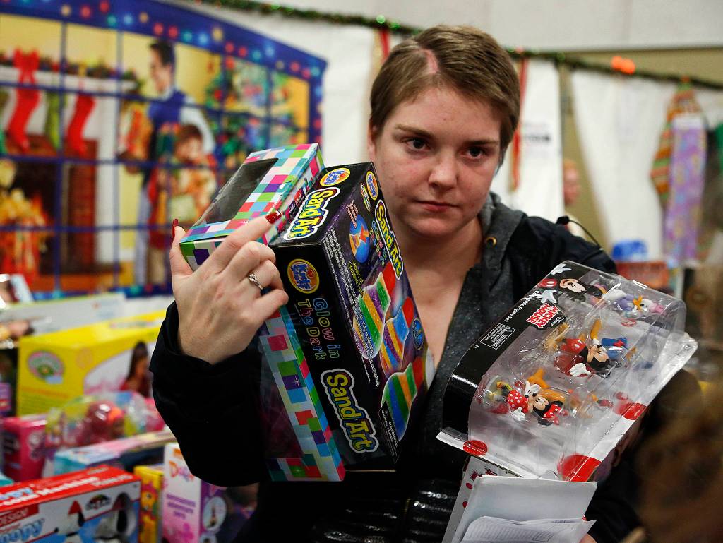 Barbara Diaz, 25, picks out toys at Christmas House at the Everett Boys & Girls Club on Dec. 15. Diaz, who has two girls and a boy, ages 4, 6 and 8, had three brain surgeries in the past year. (Dan Bates / The Herald)
