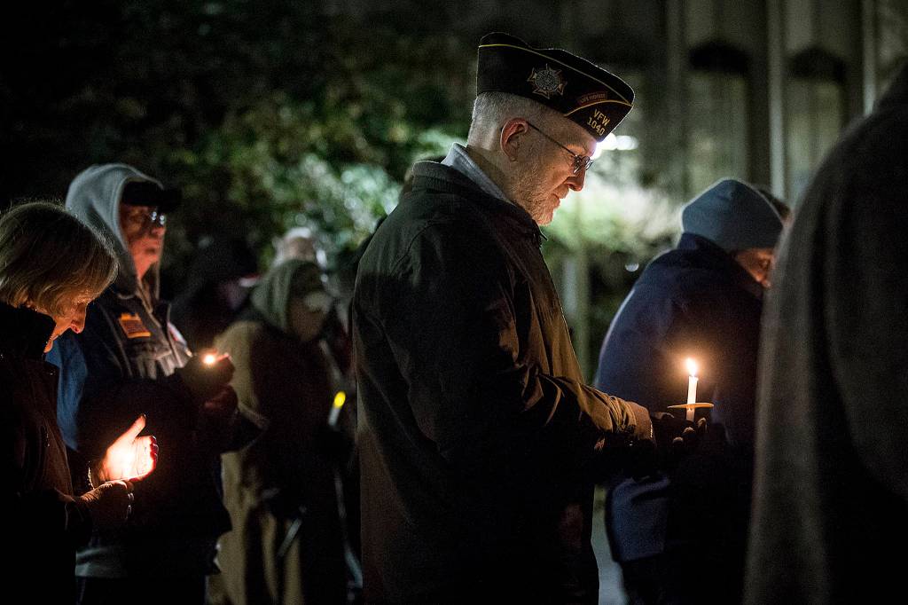 Army veteran Brian Seguin, of Everett, holds a candle at a vigil in remembrance of deaths this year within the areas homeless population outside the Snohomish County Courthouse in Everett on Dec. 21. (Ian Terry / The Herald)