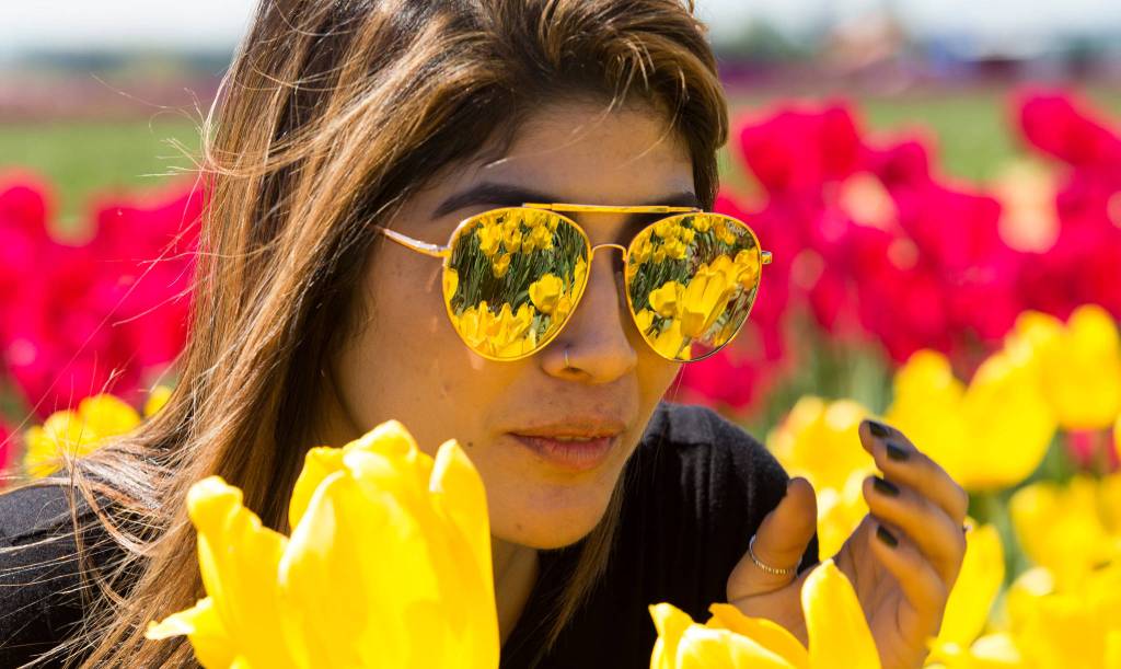 The fields at Tulip Town are reflected in the mirrored sunglasses worn by Silvia Iraheta, of Bellingham, on May 4 in Mount Vernon. (Andy Bronson / The Herald)