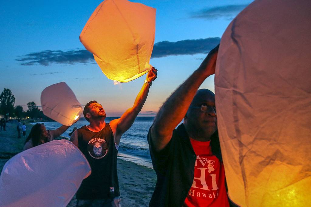 Friends and family release lanterns during the memorial barbecue for Henry Faison on Alki Beach in Seattle on July 19. Faison died in 2015 after succumbing to injuries from a gunshot wound. (Kevin Clark / The Herald)