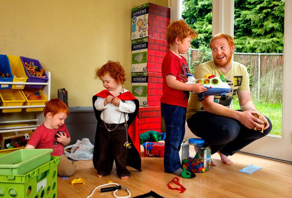 In their basement playroom June 15, Alex Clawson, 32, communicates firmly and thoughtfully with his eldest son, Willem, 4, while son Atley (left), 3, plays with 20-month-old daughter Seirsha. Clawsons wife and the childrens mother, Amy Clawson, 33, and newborn daughter Elayda died May 21 after Amy suffered heart failure. (Dan Bates / The Herald)