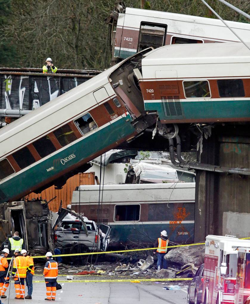Cars from an Amtrak train that derailed above lay spilled onto I-5 alongside smashed vehicles Dec. 18 in DuPont. (AP Photo/Elaine Thompson)