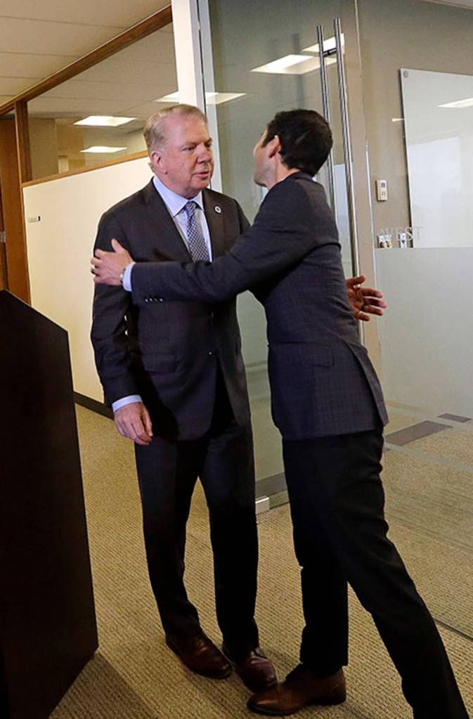 Seattle Mayor Ed Murray is greeted by his husband, Michael Shiosaki, after reading a statement to the media on April 7 in Seattle. (AP Photo/Elaine Thompson)