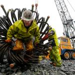Worker Justin Ryan emerges from an 80-foot-long rebar tube Thursday before it was lowered into the ground and filled with concrete to support a new pedestrian bridge being constructed will provide quicker access to the Everett waterfront. (Ian Terry / The Herald)
