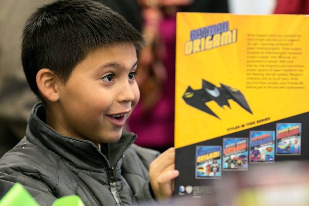 Kennan Heffernan, 8, looks through a book during the grand opening of the new Lakewood/Smokey Point Library Saturday morning in Arlington on January 6, 2018. (Kevin Clark / The Daily Herald)