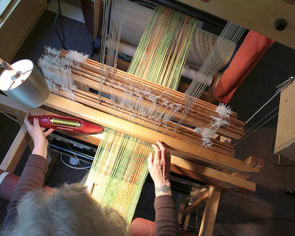 Anne Niles Davenport weaves from her home studio RainShadow Textiles in Freeland. She weaves fabrics from natural, hand-dyed fibers that can be worn or adorn the home. In the book, she describes how the art form chose her. (Don Wodjenski)