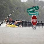 Two kayakers try to beat the current pushing them down an overflowing Brays Bayou along South Braeswood in Houston on Aug. 27 after Hurricane Harvey. (Mark Mulligan/Houston Chronicle via AP)