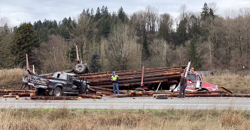 A log truck rolled onto cars in a collision that caused serious injuries and shut down U.S. 2 on Monday morning near Snohomish. (Andy Bronson / The Herald)