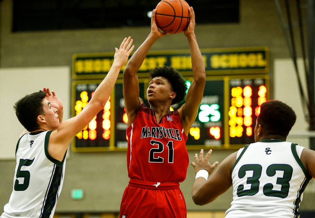 Marysville Pilchucks RaeQuan Battle (center) takes a shot as Shorecrests Chris Lee (left) and Eladio Fountain (right) defend during a game Jan. 9, 2018, at Shorecrest High School in Shoreline. (Ian Terry / The Herald)
