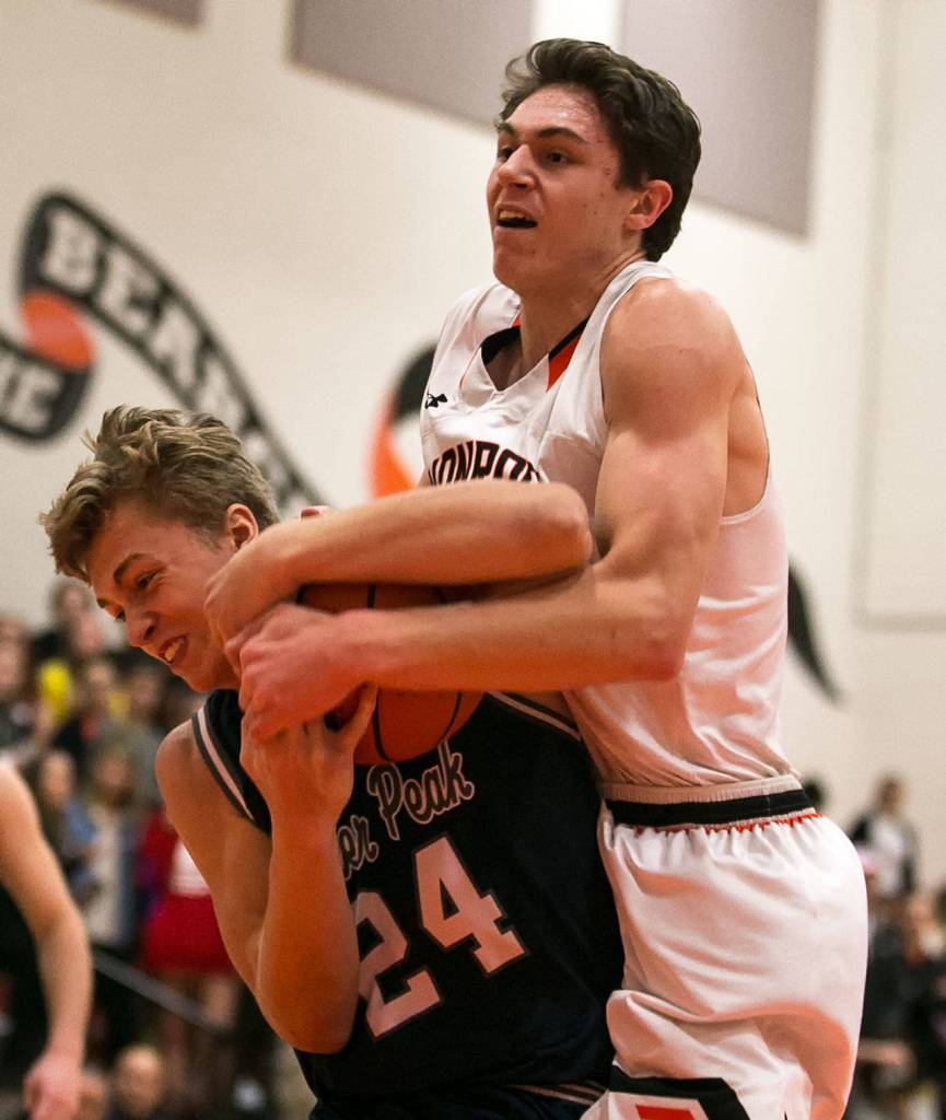 Glacier Peaks Evan Mannes (left) and Monroes Colby Kyle tie up for a jump ball during a game Jan. 10, 2018, at Monroe High School. The Grizzlies won 73-52. (Kevin Clark / The Herald)
