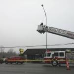 Investigators use a fire department ladder to get aerial views of the scene of a shooting on Saturday on Highway 99, between Everett and Lynnwood. (Rikki King / The Herald)