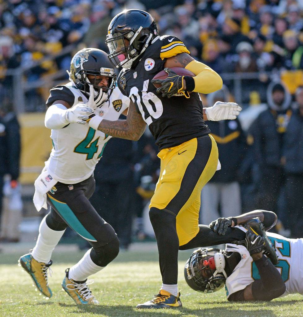 Pittsburgh Steelers running back LeVeon Bell (26) is tackled by Jacksonville Jaguars free safety Tashaun Gipson, lower right, and strong safety Barry Church, left, during the first half of an NFL divisional football AFC playoff game in Pittsburgh, Sunday, Jan. 14, 2018. (AP Photo/Don Wright)