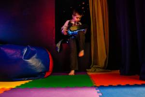 Hunter Standley, 6, scoots backward into a cozy cubbyhole in Wee Fits sensory room while holding an artificial aquarium. Hunter, who has autism, is with his mom, Breanna Standley, 25, and his grandmother, Barbara Bambrick, 63. They are all from Tulalip. (Dan Bates / The Herald)