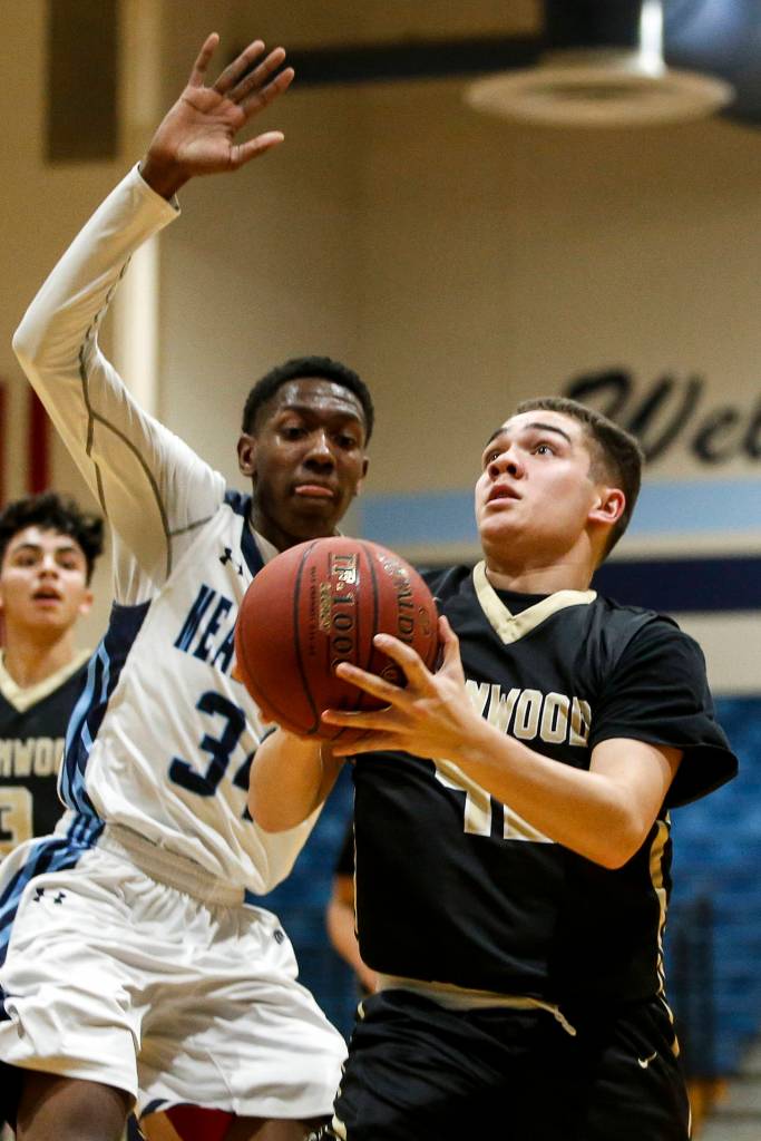 Lynnwoods Jordan Glover (right) drives to the hoop as Meadowdales Justin Chambers defends during a game on Jan. 16, 2018, at Meadowdale High School in Lynnwood. (Ian Terry / The Herald)