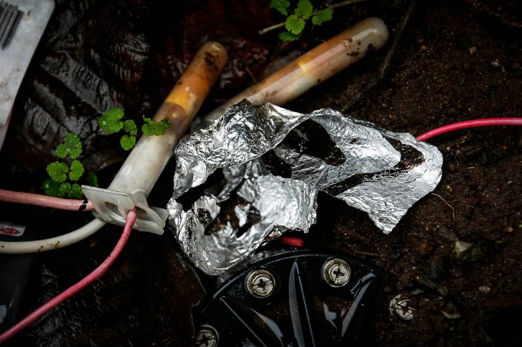 Heroin inside tinfoil is seen at a former homeless encampment in Arlington on Tuesday. (Ian Terry / The Herald)