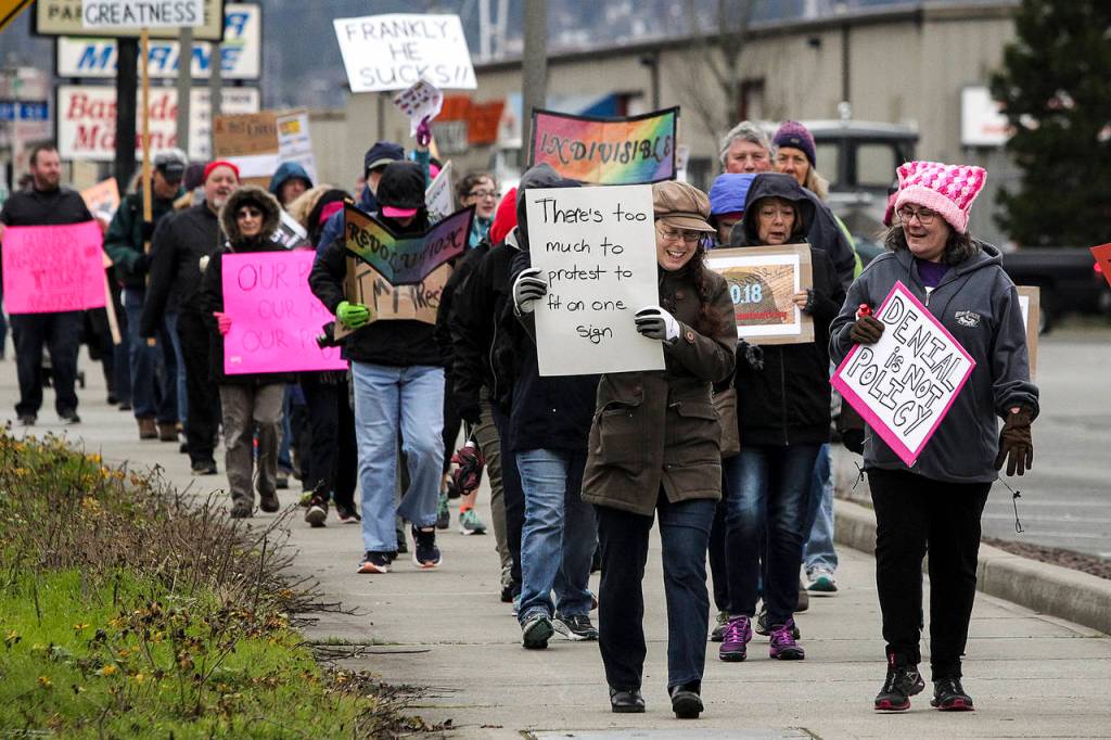 People walk in Everetts March to Impeach along West Marine View Drive on Saturday. (Ian Terry / The Herald)