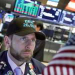 Specialist Michael Pistillo wears a Dow 26,000 hat as he works on the floor of the New York Stock Exchange on Wednesday. (AP Photo/Richard Drew)