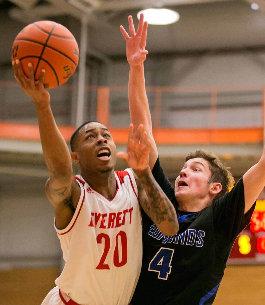 Everett Community Collefges Tori Odom (20) attempts a shot with Edmonds Community Colleges Thomas Doyle defending during a game Jan. 20, 2018, at the Walt Price Student Fitness Center in Everett. The Trojans won 117-100. (Kevin Clark / The Herald)