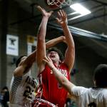 Stanwoods Mitch Jones (center) takes a shot during a game against Arlington on Jan. 26, 2018, at Arlington High School. (Ian Terry / The Herald)