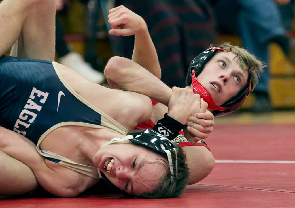 Marysville Pilchucks Tanner Lauzon (right) locks Arlingtons Dorian Tollenaar at Marysville Pichuck High School on Jan. 25. The Tomahawks won 59-11 to claim the 3A Wesco Championship. (Kevin Clark / The Herald)