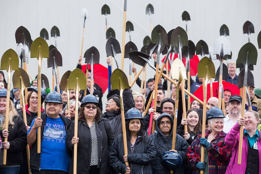 Stillaguamish tribal members and guests hold up shovels during a groundbreaking ceremony for a new $60 million expansion at the Angel of the Winds Casino Resort on Jan. 23 in Arlington. (Andy Bronson / The Herald)