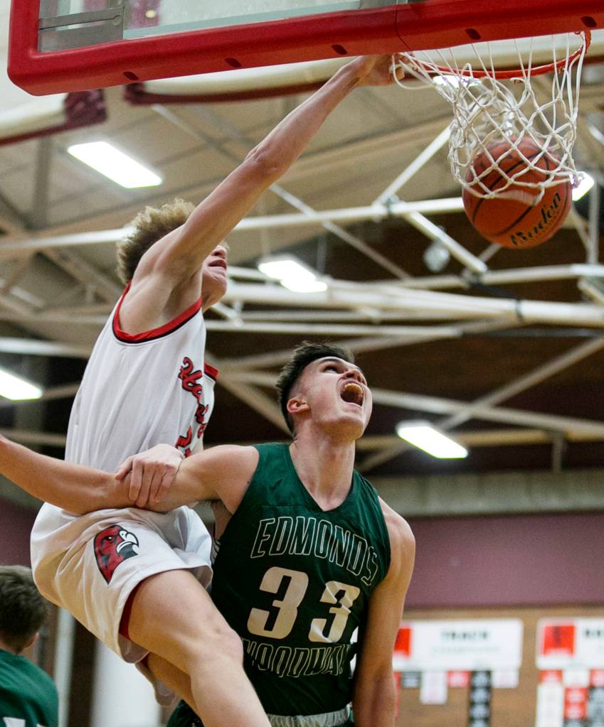 Mountlake Terrances Khyree Armstead dunks and is fouled by Edmonds-Woodways Kameron Eck at Mountlake Terrace High School on Jan. 23. (Kevin Clark / The Herald)