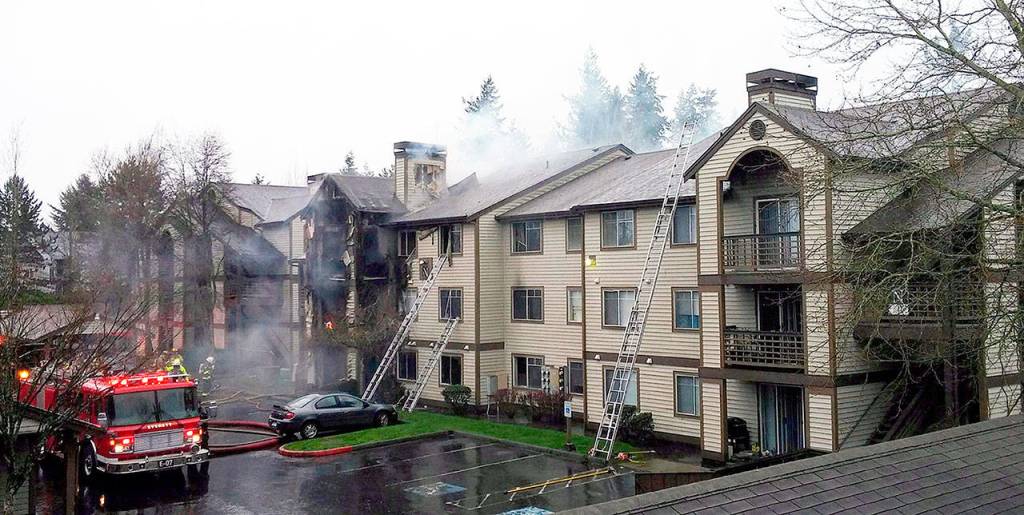 Firefighters on the scene Monday at apartments at 10115 Holly Drive in Everett. (Rikki King / The Herald)