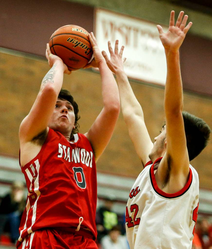 Stanwoods Mitch Jones (left) takes a shot as Mountlake Terraces Max Hull (right) defends during a game at Mountlake Terrace High School on Tuesday, Jan. 30. (Ian Terry / The Herald)
