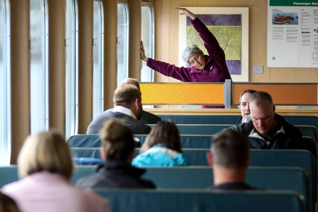 Jill Hummelstein stretches during her morning ferry commute. (Kevin Clark / The Herald)