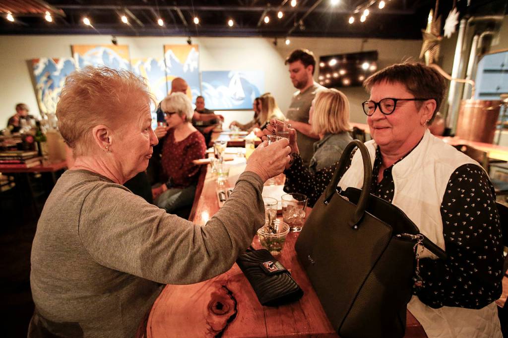 Friends Donna Massick (left) and Jo Rogers enjoy a cocktail together during a class at Bluewater Distilling in Everett. (Ian Terry / The Herald)