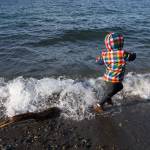 After getting his shoes soaked, Anthony Naczelnik, 3, of Edmonds, runs from the waves before hundreds of people jump into Puget Sound. (Andy Bronson / The Herald)
