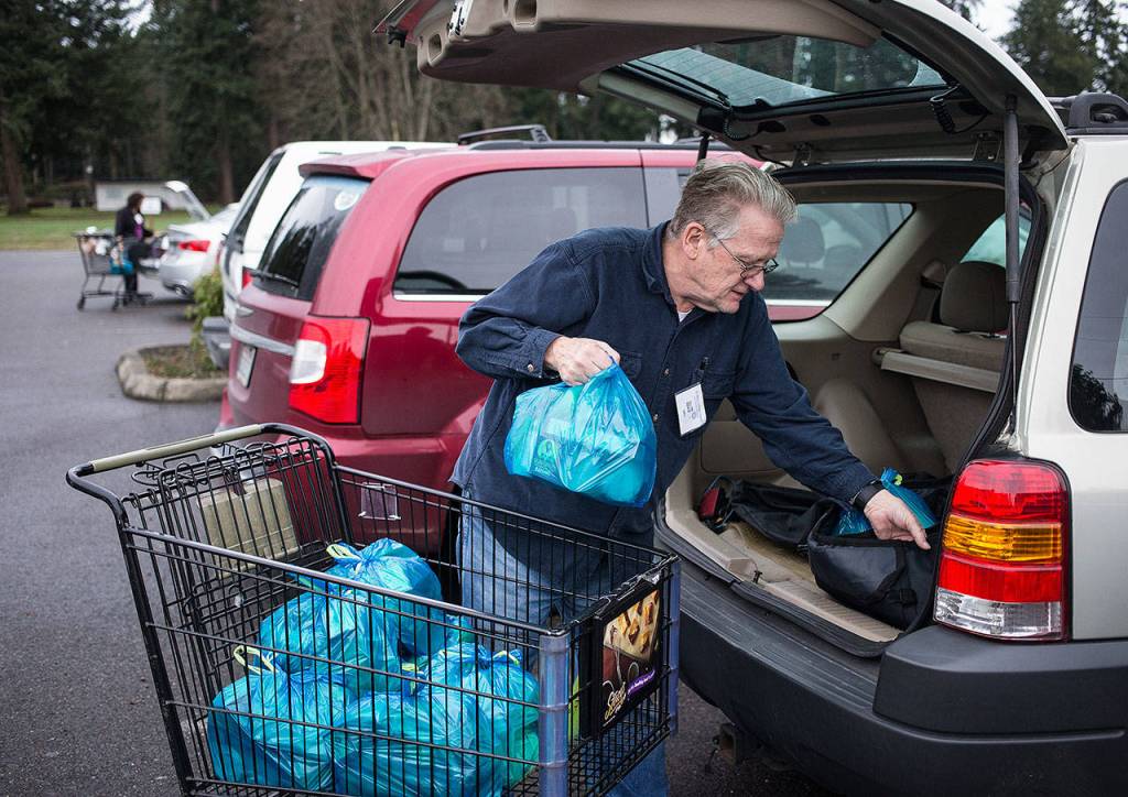 St. Mary Catholic Church Backpack Ministries volunteer Jim Fowbell packs his SUV with bags of food to take to needy families at Cascade Elementary on Jan. 25 in Marysville. (Andy Bronson / The Herald)