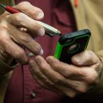Dell Johnson uses a stylus on his smartphone to save location data for his favorite fishing holes while attending a smartphone class at the Carl Gipson Senior Center on Thursday in Everett. (Andy Bronson / The Herald)