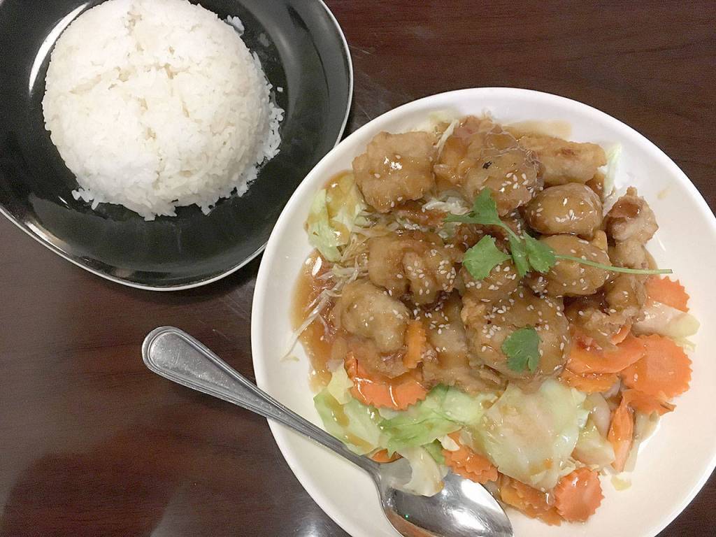 The crispy chicken lover comes with sliced carrot, cabbage, lettuce, and your choice of orange, sesame, or volcano sauce, with a side of jasmine rice at Bua Thai Fusion in Lake Stevens. (Ben Watanabe / The Herald)