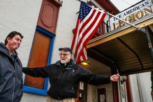 Just outside Stanwoods American Legion Post 92 Thursday, Navy veteran and Post Chaplain Phil Lewis, 85, talks about major work needed on the building, which is only a few years younger than he is. Post Cmdr. Gina Seegert might appear to be suffering from a little sticker shock, considering they need to raise $90,000. (Dan Bates / The Herald)
