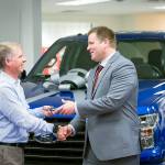 Epic Ford owner Jeff Swickard hands over the keys of a new Ford F-150 to U.S. Army veteran Kyle Storbakken as Rachel Chambers, who entered Storbakken in the Nominate a Hero promotion, looks on. (Contributed photo by Peter Vandenbelt)