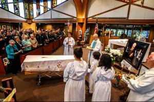 At a funeral Mass for Sister Barbara Geib at St. Mary of the Valley Catholic Church in Monroe Thursday, the Rev. Phillip Bloom officiates as police, firefighters, nuns from Geibs religious order and others listen and take part. Geib, a parish sister at the church, was Monroes first police chaplain. (Dan Bates / The Herald)
