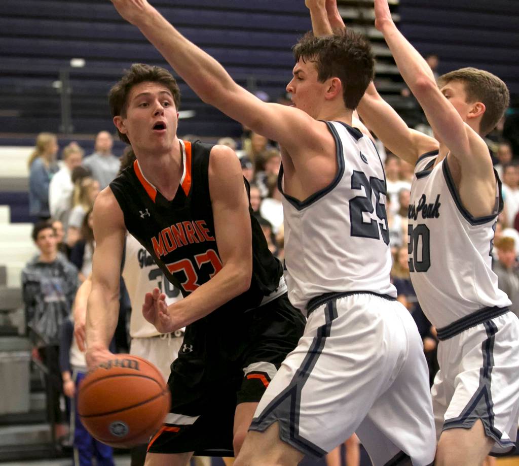 Monroes Colby Kyle looks to pass with Glacier Peaks Noah Forman (25) and Fletcher Douglas defending at Glacier Peak High School in Snohomish on Feb. 1. (Kevin Clark / The Herald)