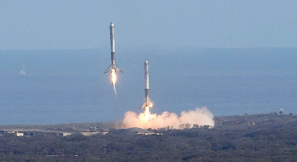 Two booster rockets from the SpaceX Falcon Heavy rocket return for a landing at Kennedy Space Center in Cape Canaveral, Florida, on Tuesday. (AP Photo/John Raoux)