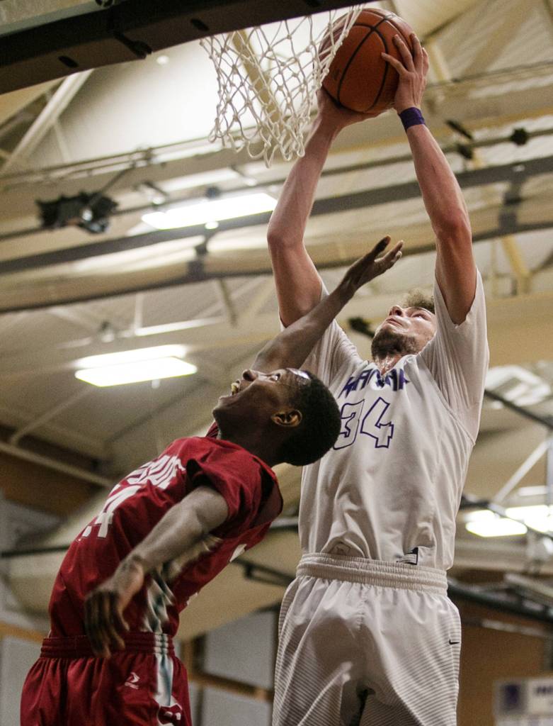 Kamiaks Daniel Sharpe rebounds and scores over Cascades Musa Baldeh at Kamiak High School in Mukilteo on Feb. 8. (Kevin Clark / The Daily Herald)