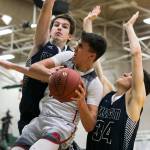 Marysville Pilchucks Josiah Gould attempts a shot with Arlingtons Max Smith (left) and Josh Gutierrez defending during a district playoff game on Feb. 14, 2018, at Jackson High School in Mill Creek. (Kevin Clark / The Herald)