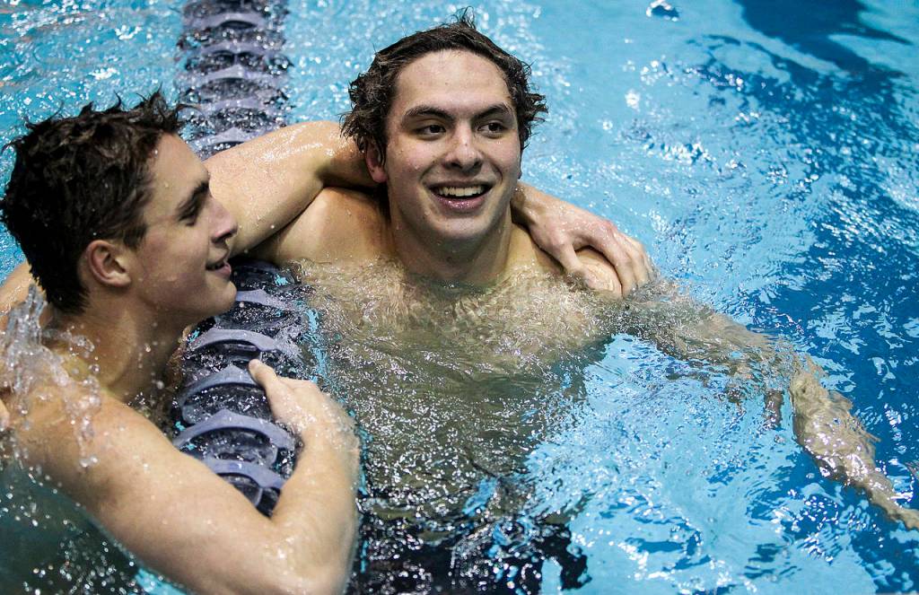Jacksons Jonathan Cook (right) is congratulated on his victory in the 100-yard breaststroke race Saturday by second-place finisher Alejandro Flores of Lake Stevens during the 4A state boys swimming and diving championship at the King County Aquatic Center in Federal Way. (Ian Terry / The Herald)