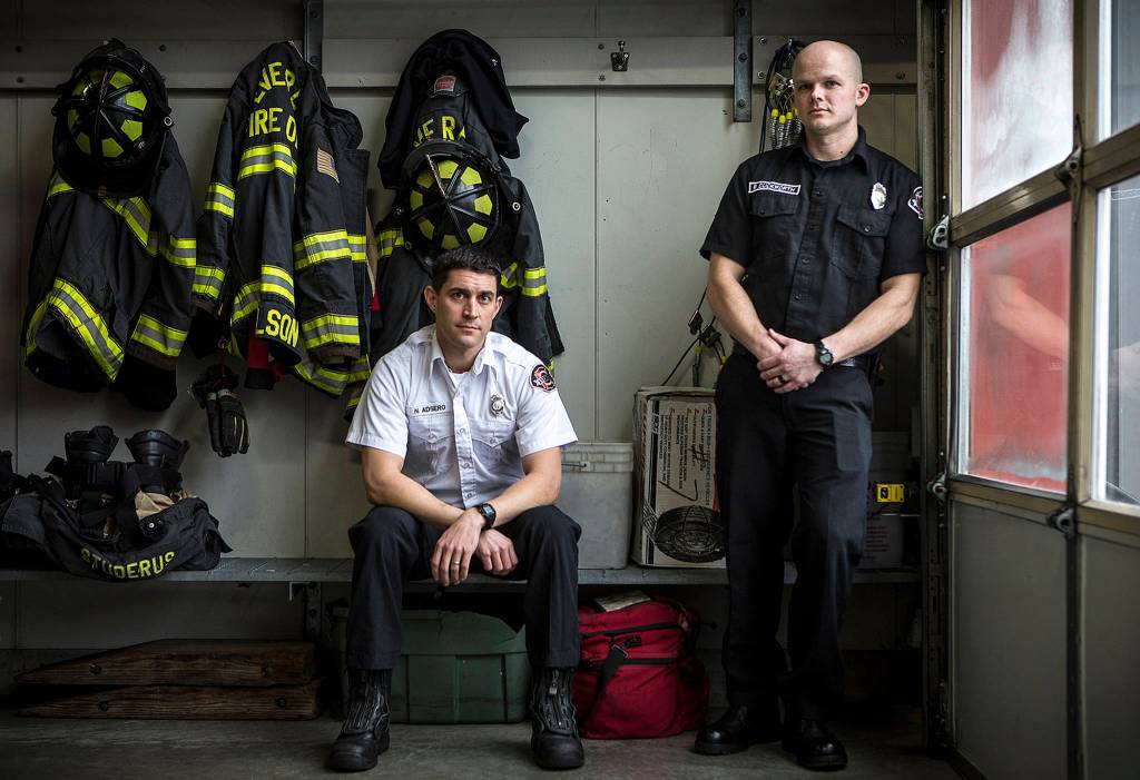 Capt. Nick Adsero (left) and firefighter Brent Duckworth braved thick black smoke and flames to save trapped 3-year-old twin sisters Chloe and Emma Orick at a Jan. 29 fire at Olin Fields Apartments in Everett.<strong> </strong>(Ian Terry / The Herald)