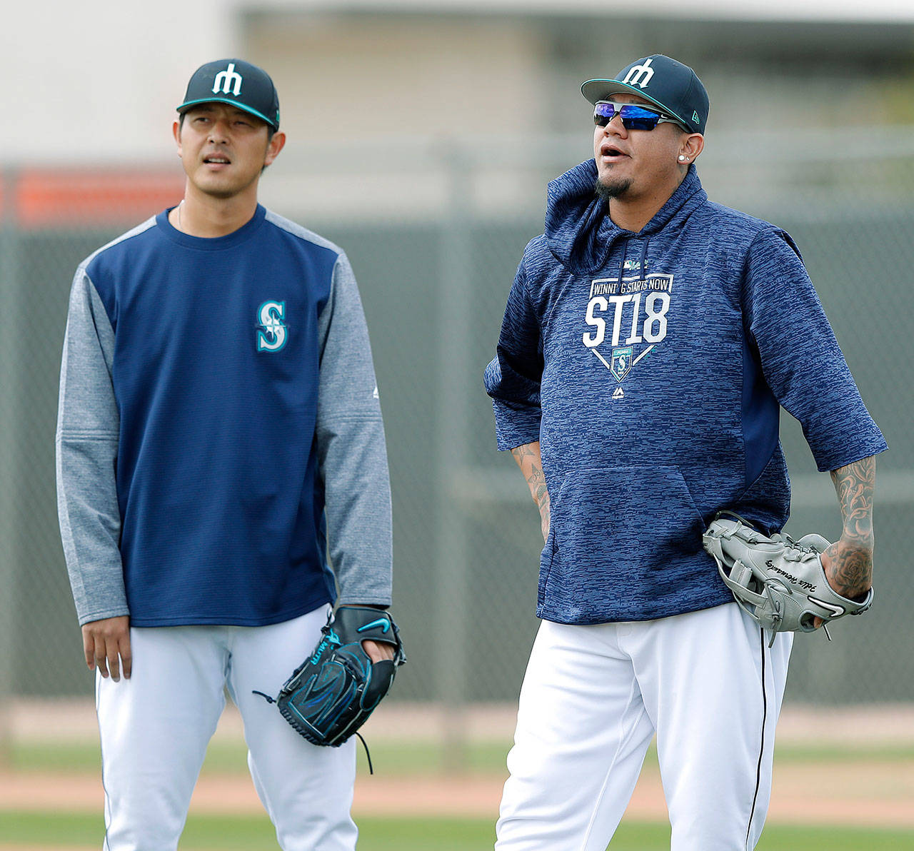 Seattles Felix Hernandez (right) and Hisashi Iwakuma watch a drill during spring training on Monday in Peoria, Ariz.(AP Photo/Charlie Neibergall)