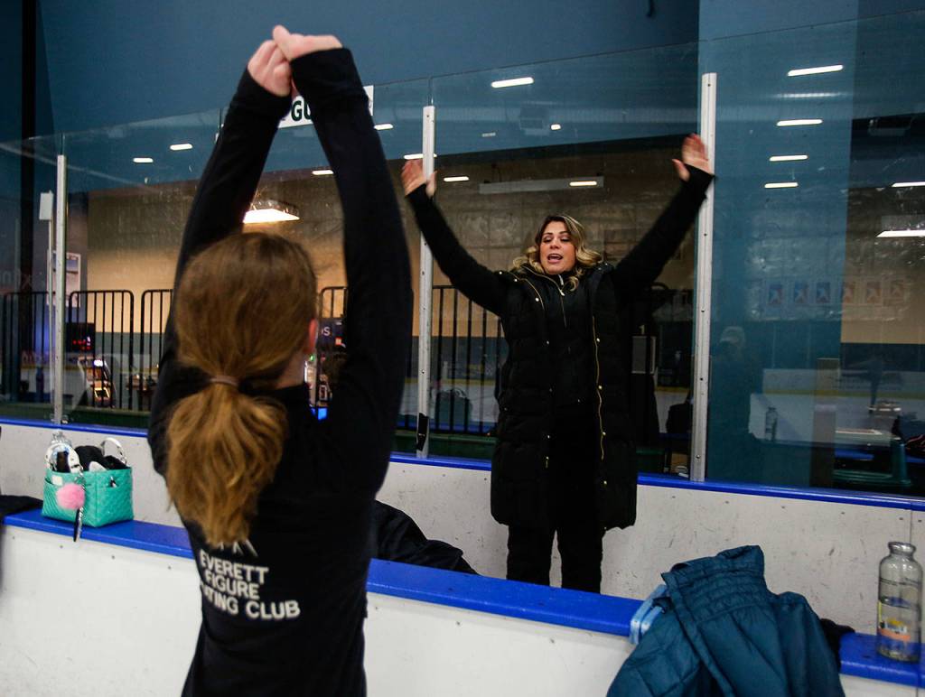 Everett Figure Skating Club coach Susannah Hall McAllister (facing) is 9 months pregnant on this day, but she can still show Erica Walter, 12, (foreground) how she would like her to work on a move. (Dan Bates / The Herald)