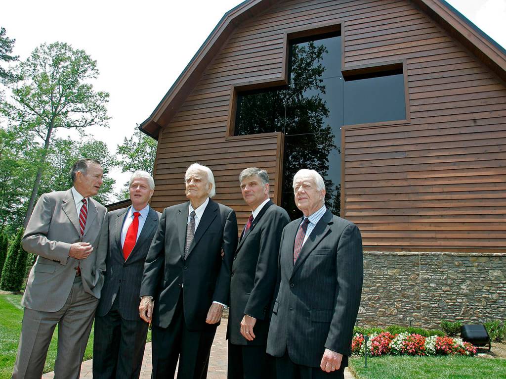 In this May 31, 2007 photo, former Presidents George H.W. Bush (left), Bill Clinton (second left) and Jimmy Carter (right) join Franklin Graham (second right) as they pose with Billy Graham (center) in front of the Billy Graham Library in Charlotte, North Carolina. (AP Photo/Chuck Burton, File)